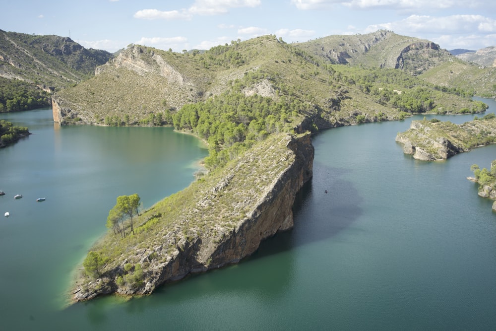 green lake surrounded by green trees and mountains during daytime