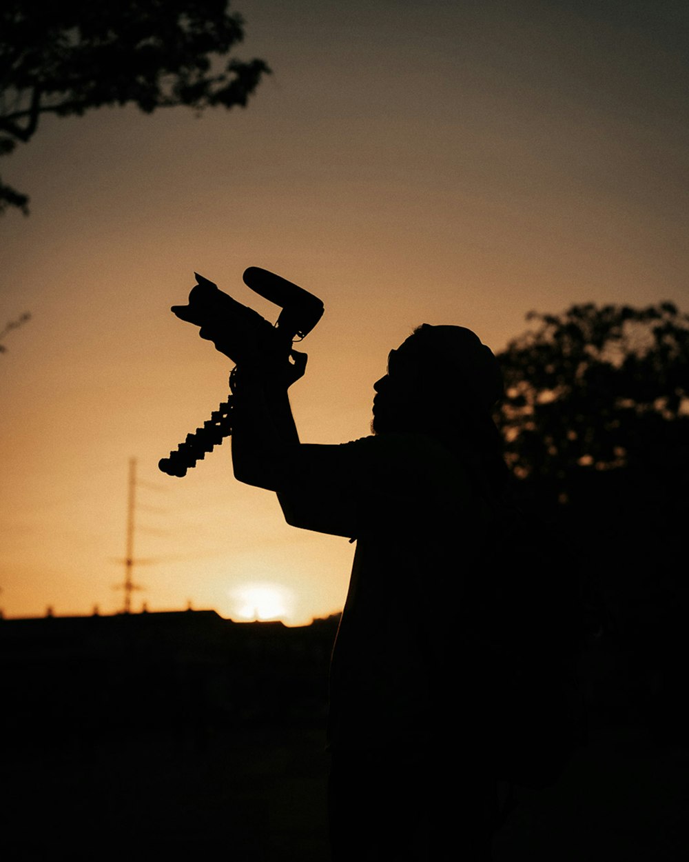 silhouette of man holding trumpet during sunset