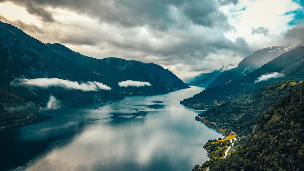 lac au milieu des montagnes sous les nuages blancs