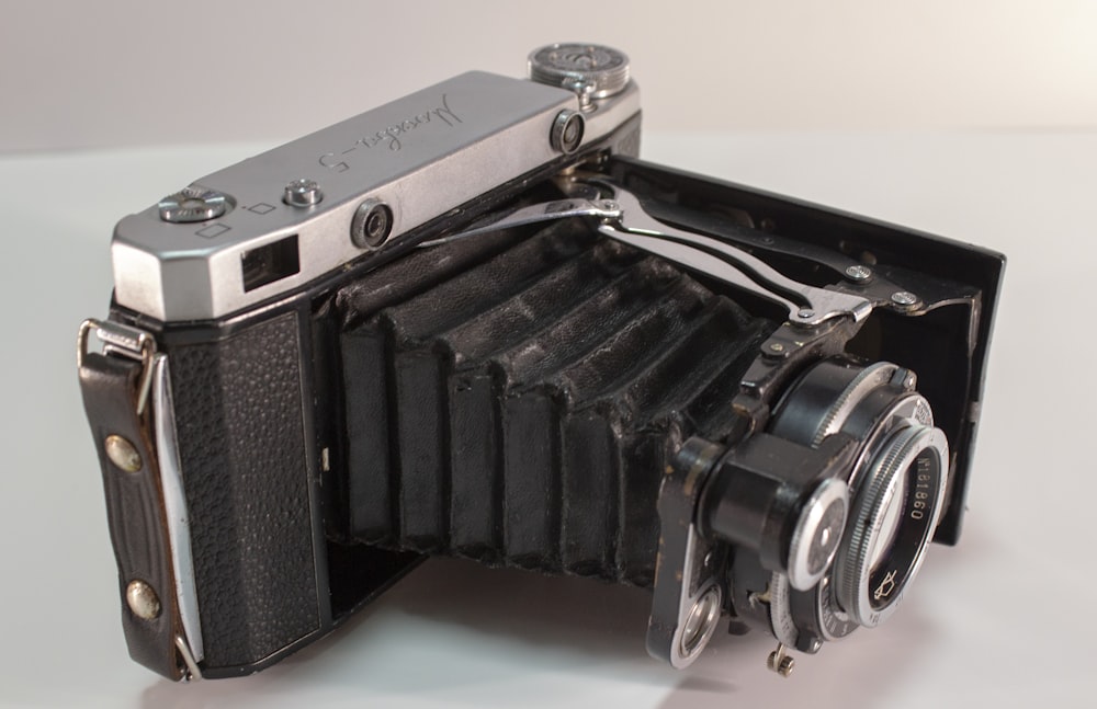 black and silver camera on white table