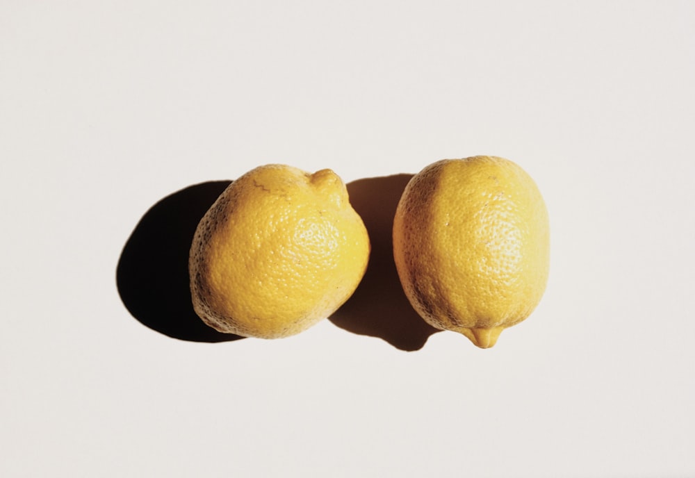 2 gelbe Zitronenfrüchte auf weißer Oberfläche