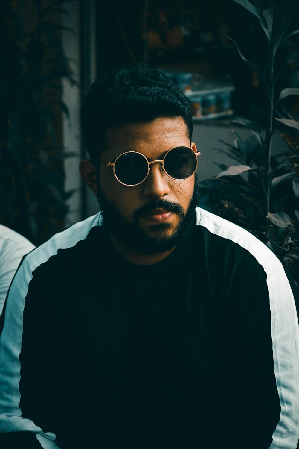 man in black crew neck shirt wearing white framed sunglasses