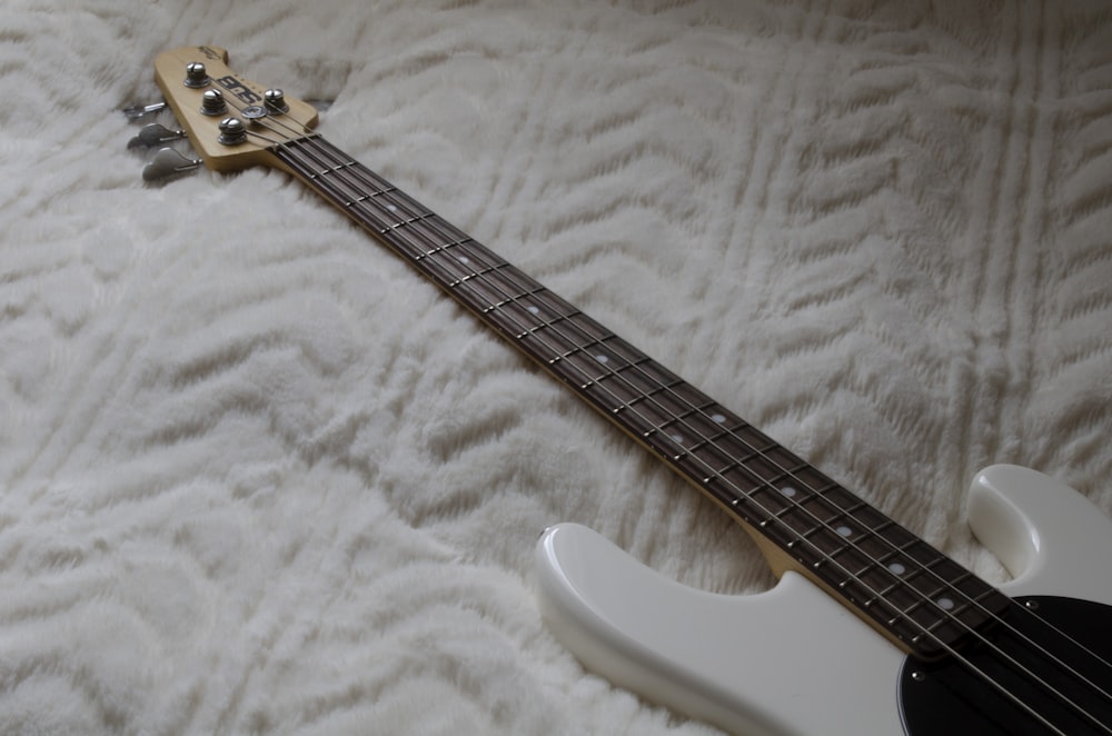 white electric guitar on white textile