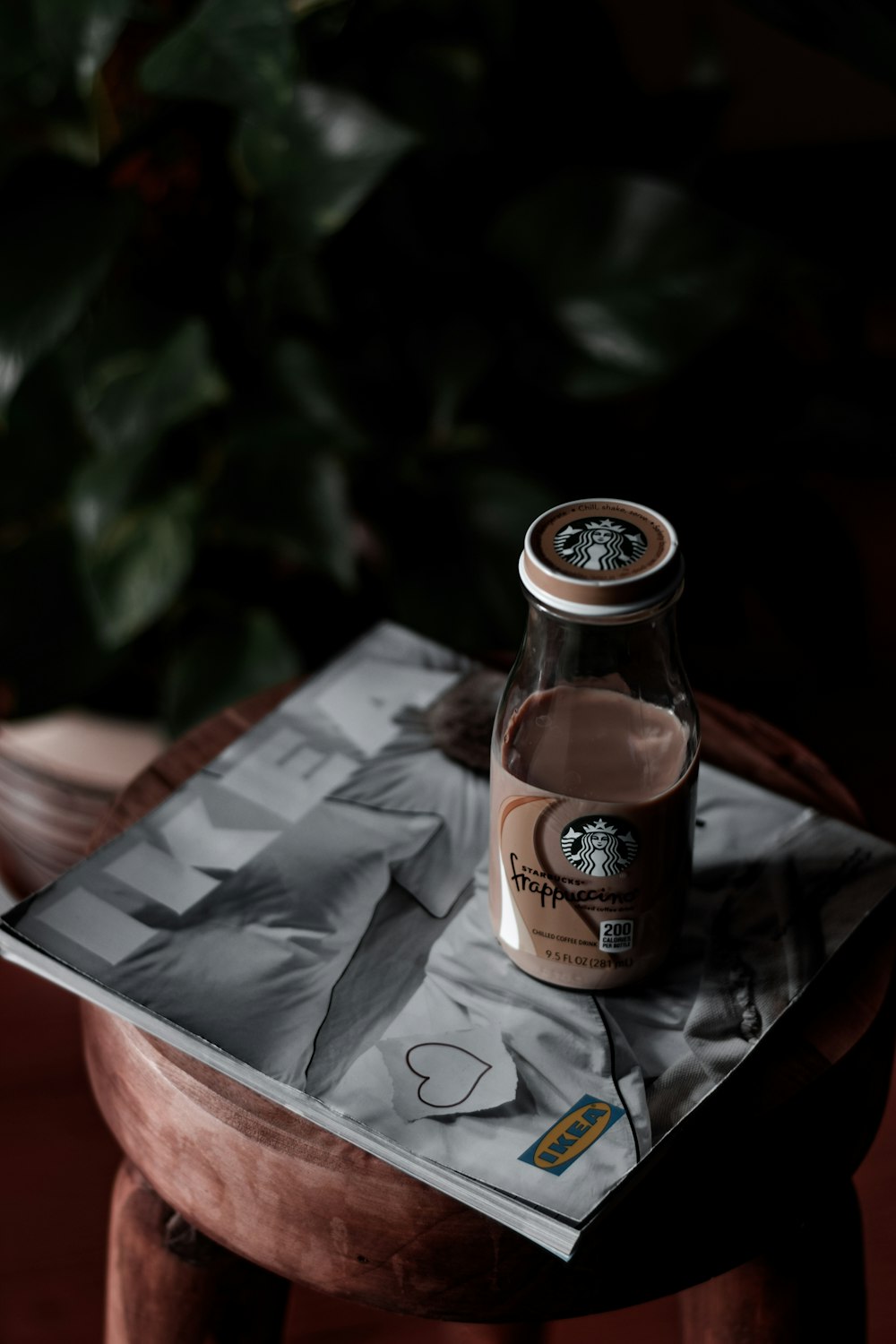 brown and black labeled bottle on white and black book