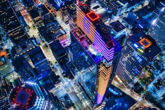 A vibrant aerial view of a neon-lit digital cityscape glowing under a night sky, alive with energy and movement.