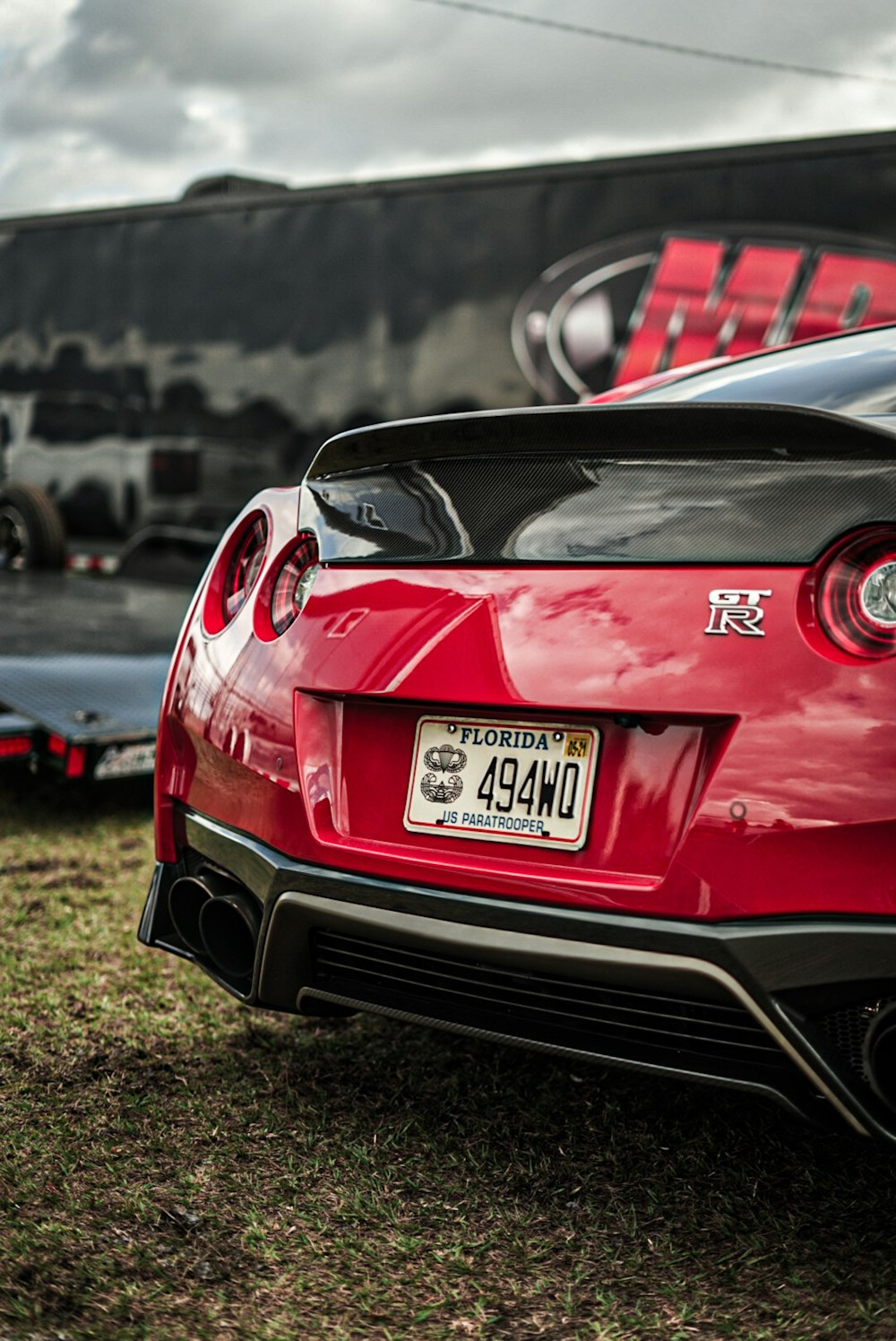 red bmw m 3 parked on green grass field during daytime