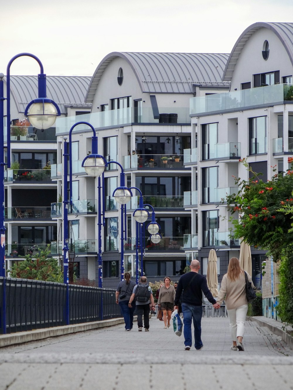 people walking on sidewalk near white building during daytime