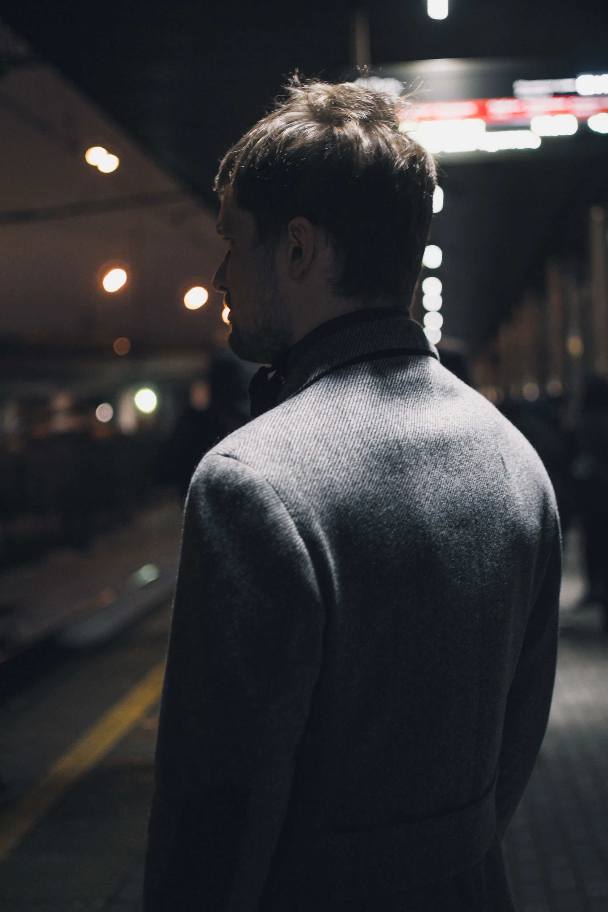 A man in a black overcoat on a night street