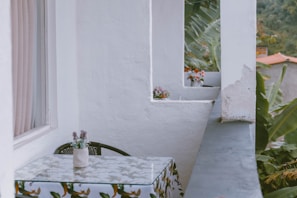 Private balcony with seating area surrounded by tropical plants.