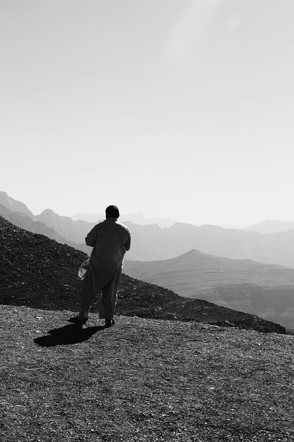 man in black jacket standing on rock formation during daytime