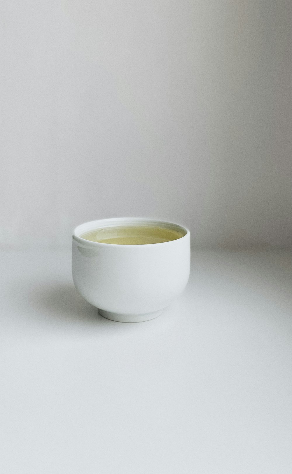 white ceramic cup on white table