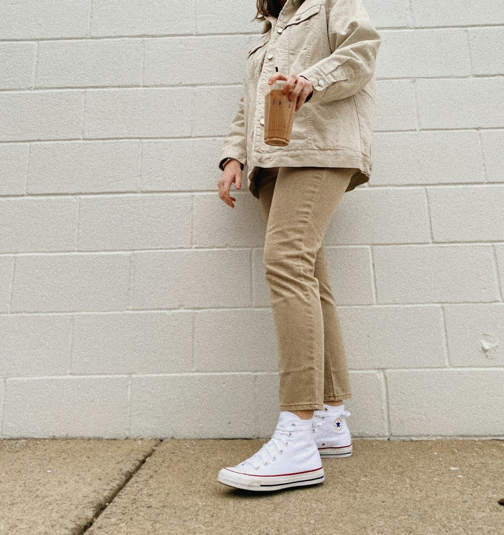 person in brown pants and white sneakers