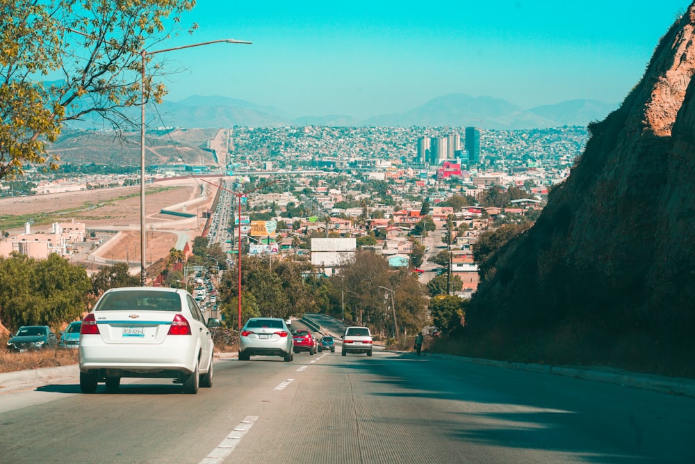 cars on road near city buildings during daytime