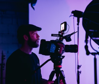 man in black crew neck shirt holding black dslr camera