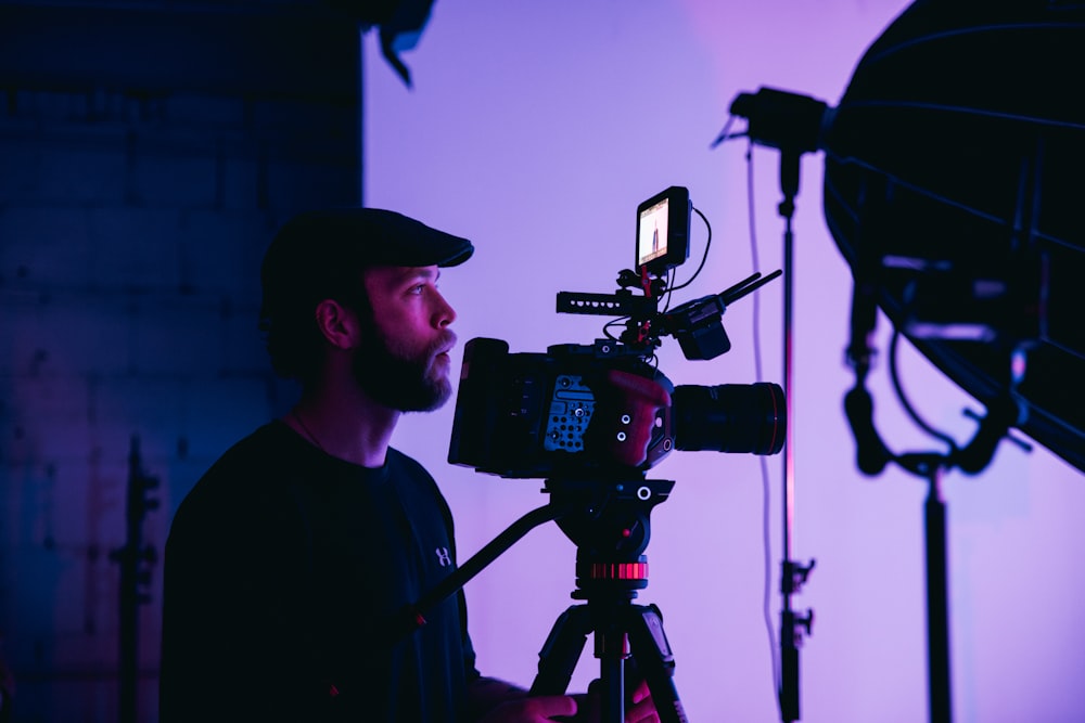 man in black crew neck shirt holding black dslr camera