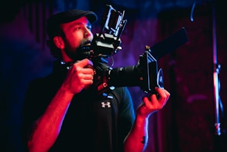 man in black t-shirt holding black camera