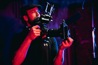 man in black t-shirt holding black camera