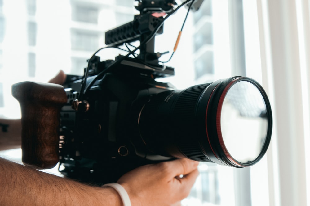 person holding black dslr camera