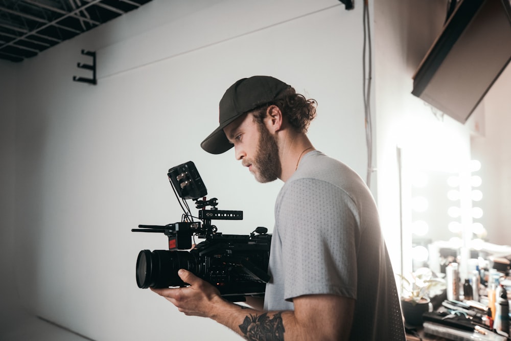 man in gray crew neck t-shirt holding black video camera