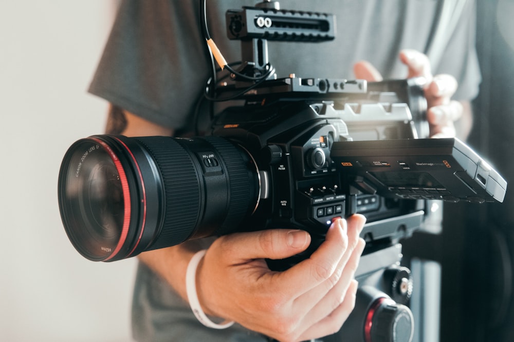 person holding black dslr camera