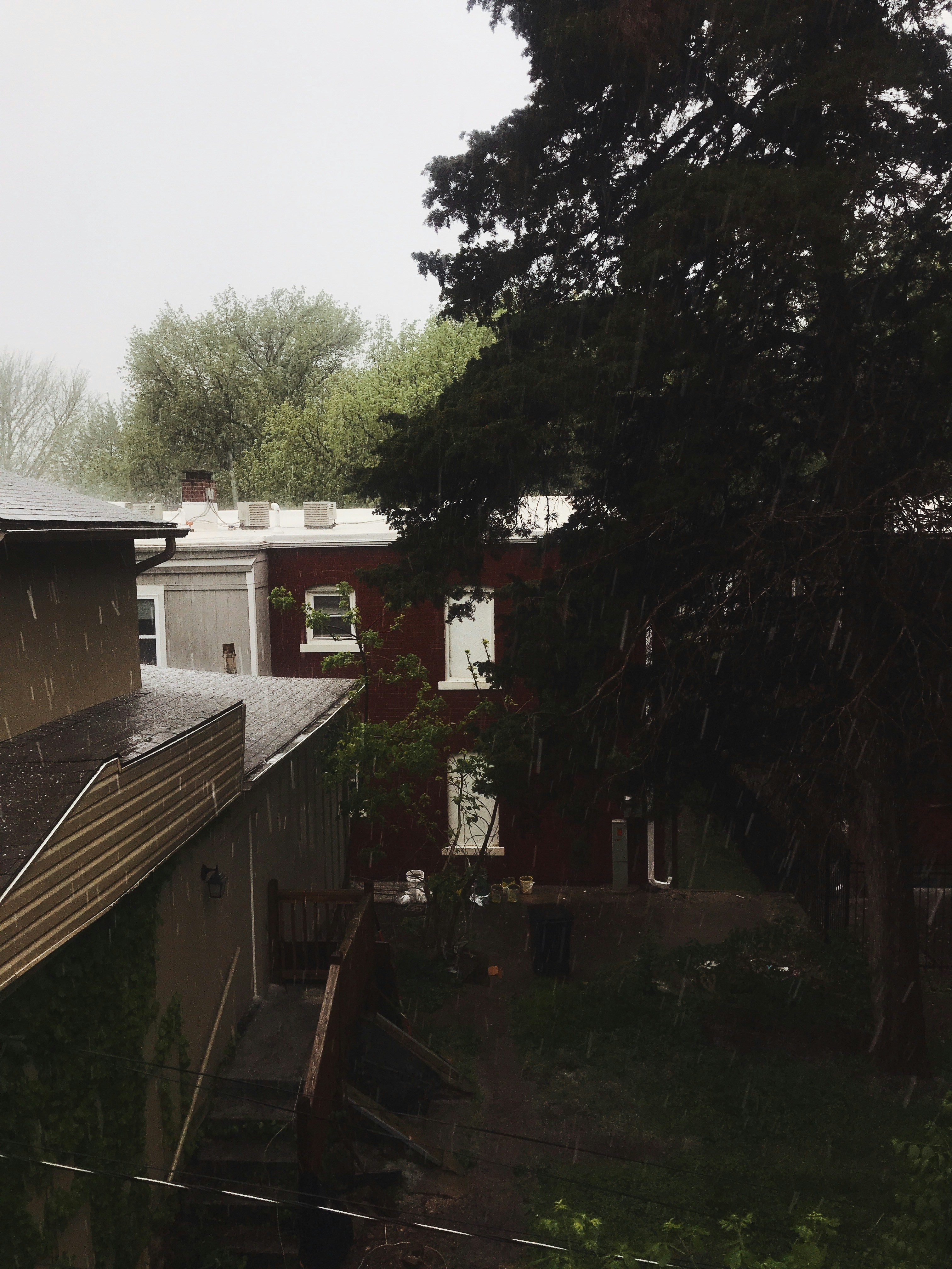 brown and white concrete house near green trees during daytime