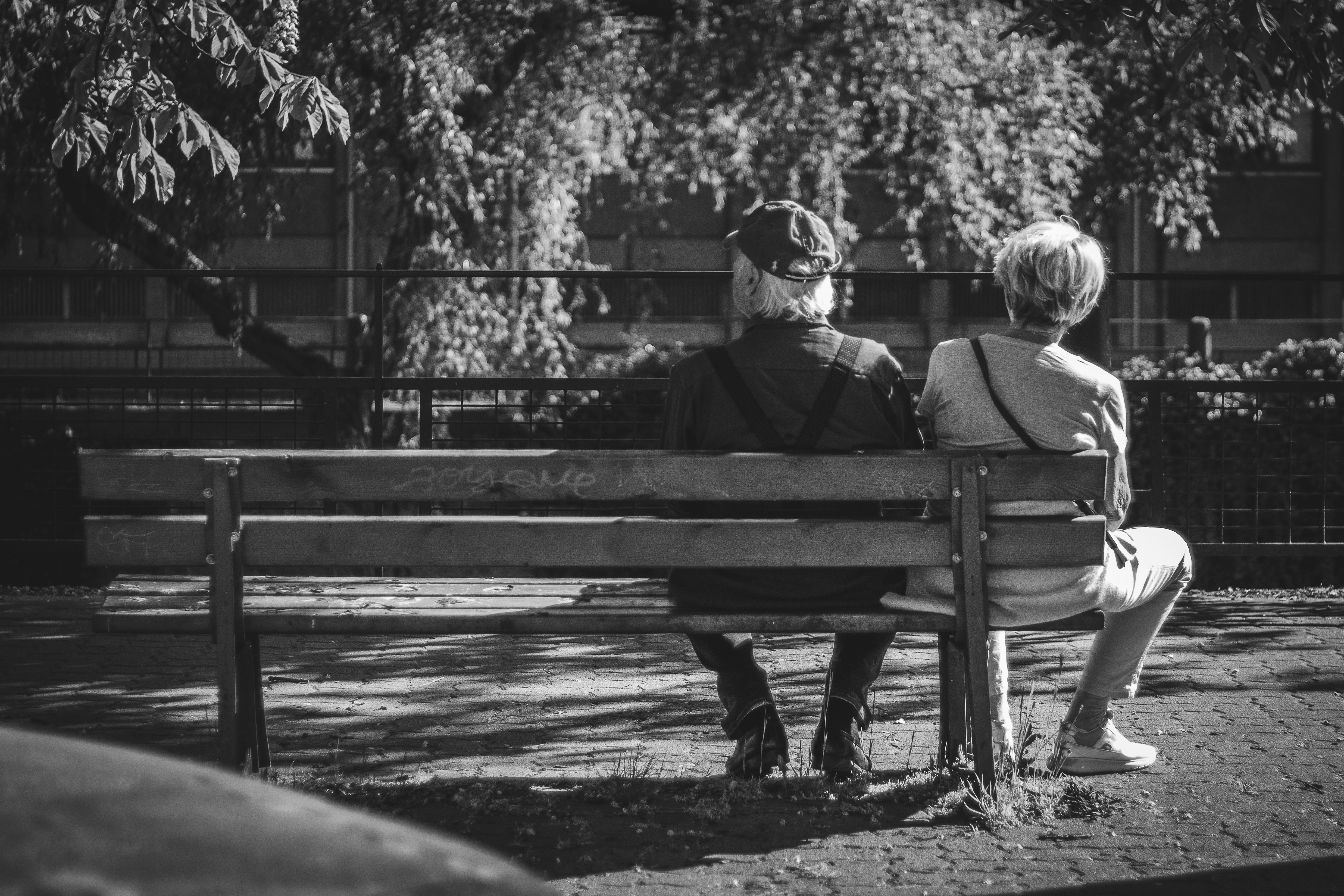 grayscale photo of 2 children sitting on bench