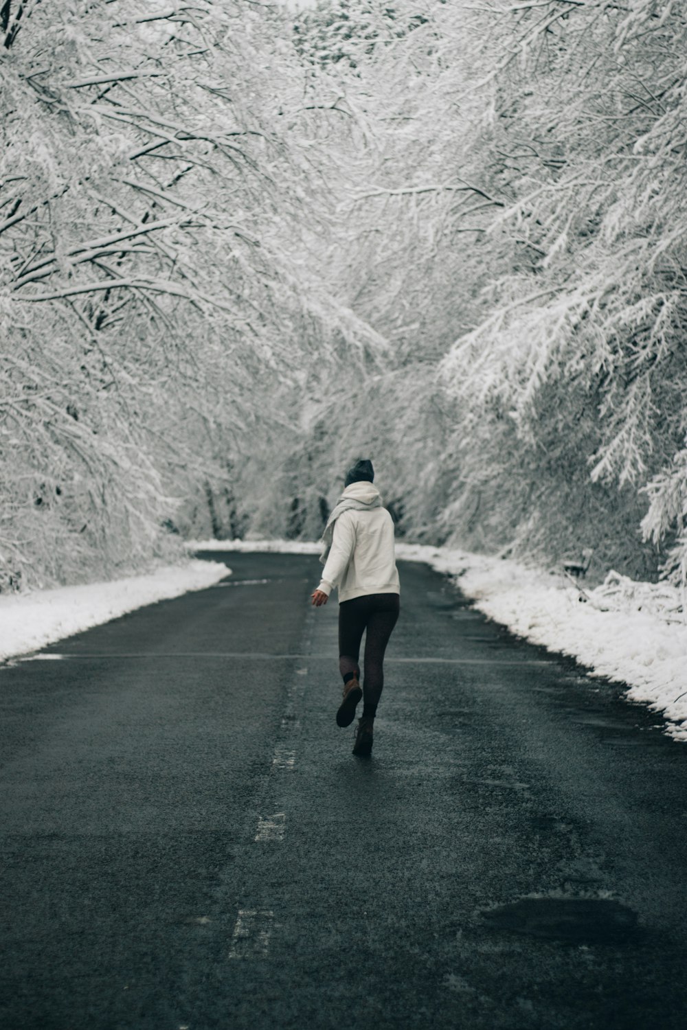 woman in beige coat walking on road