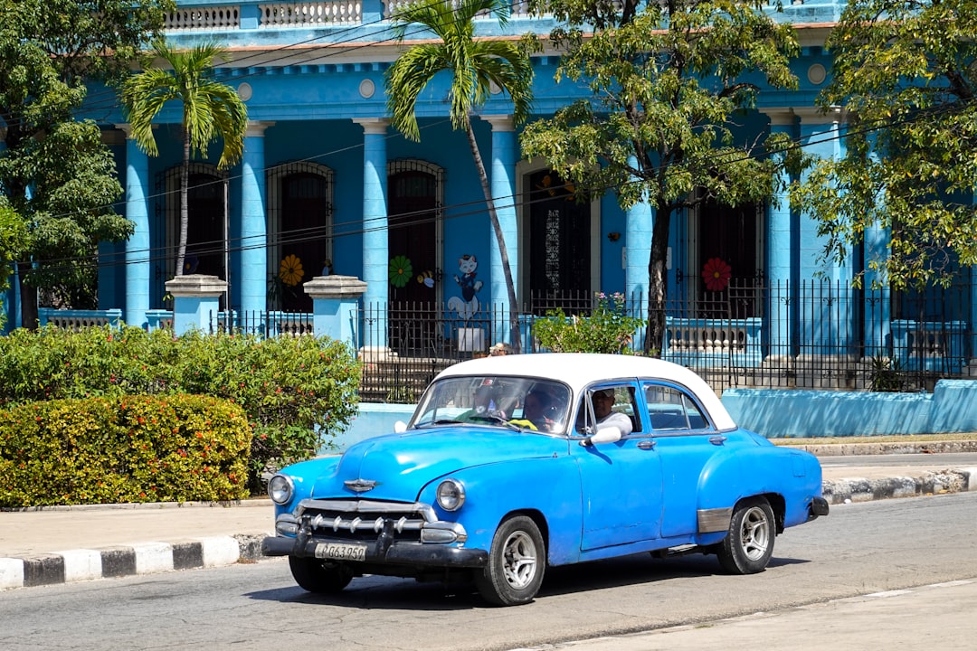 blue and white vintage car parked on roadside during daytime