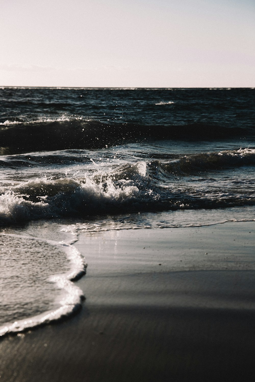 ocean waves crashing on shore during daytime