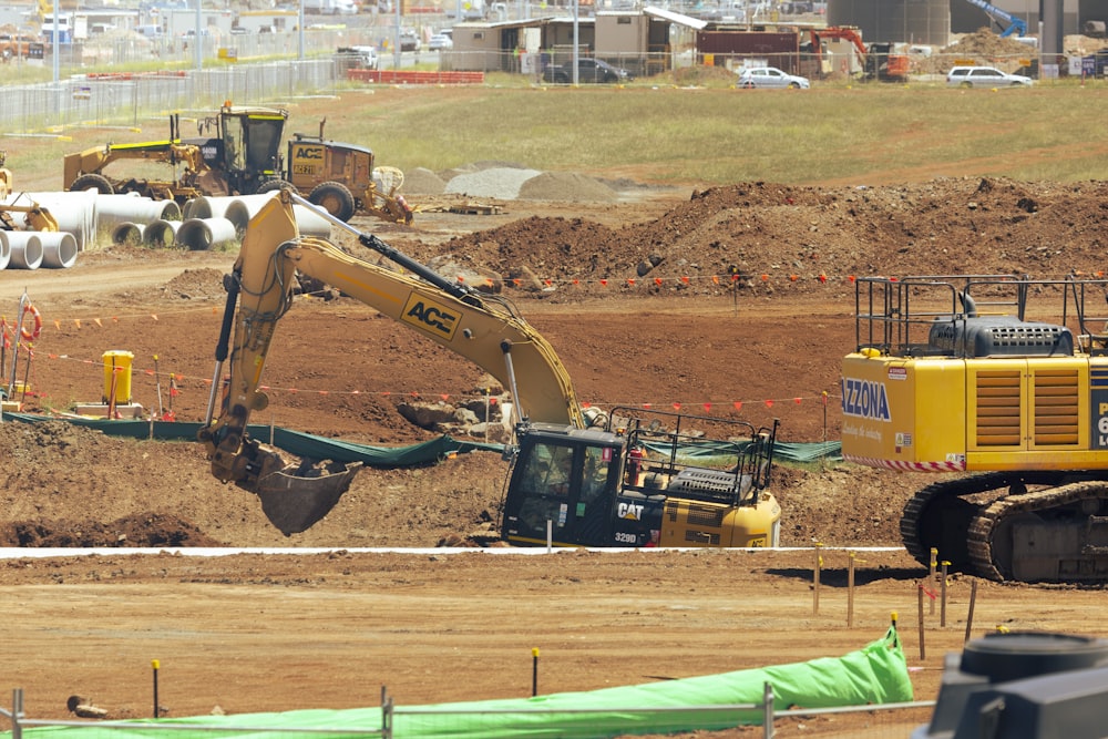 yellow and black excavator on brown field during daytime