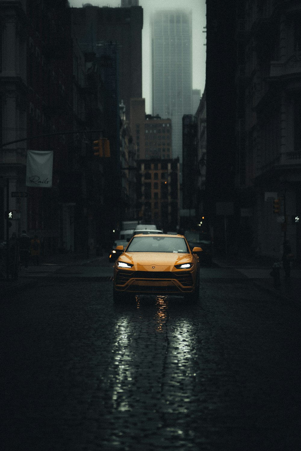 yellow car on road between buildings during night time