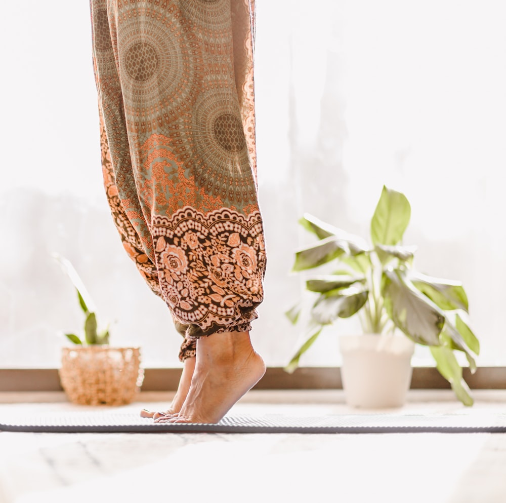 Persona en falda floral marrón y beige de pie sobre mesa blanca