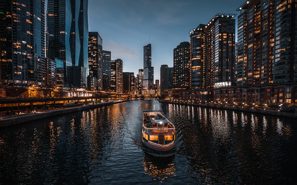 boat on river near city buildings during night time