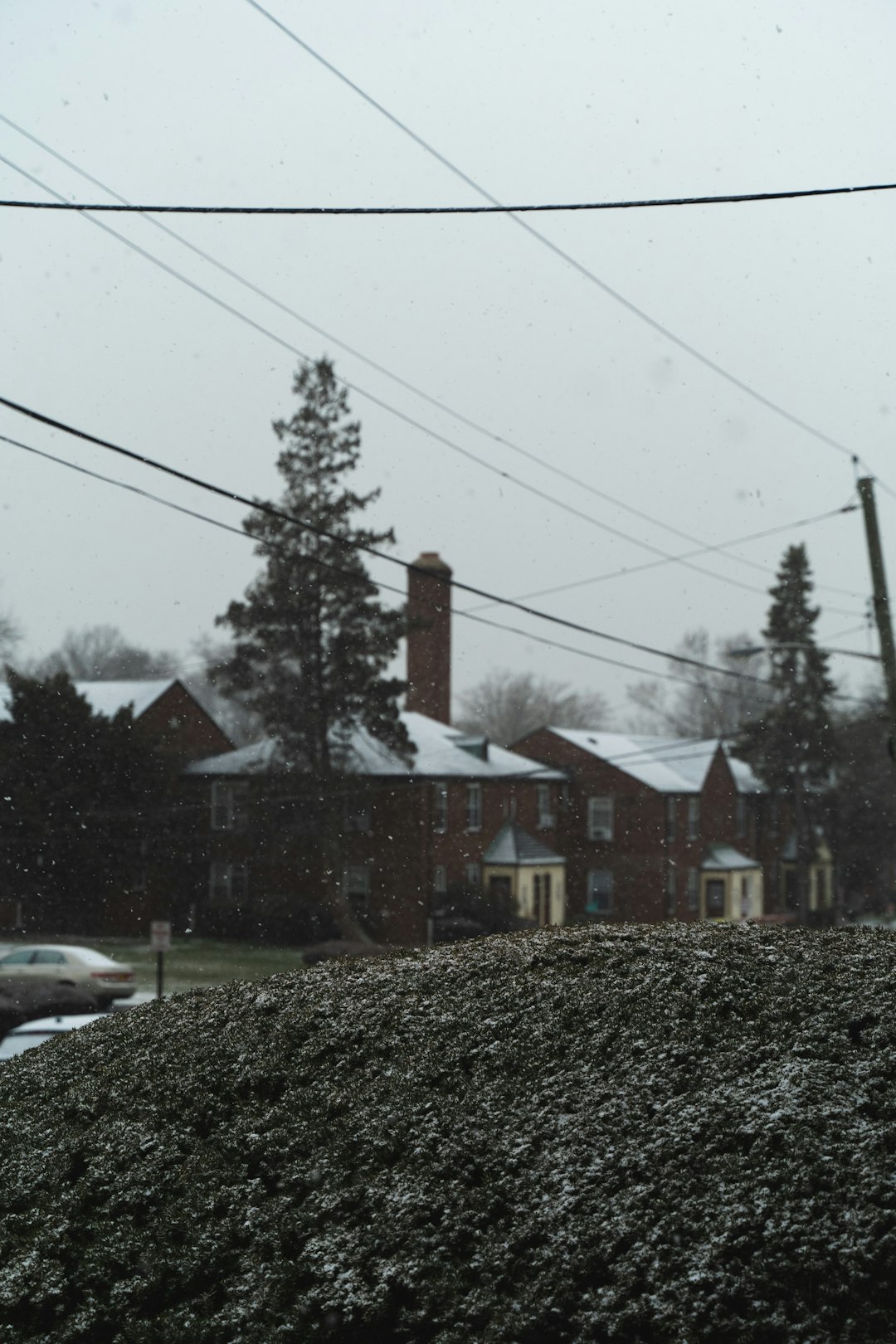 white car parked beside brown house during daytime