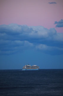 Elegant Crystal Cruises ship sailing calmly at sunset with pastel skies.