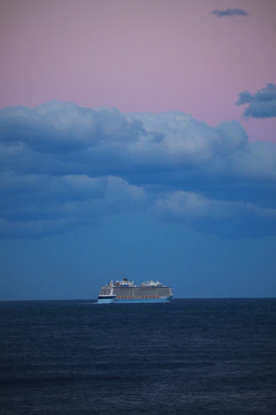 Elegant Crystal Cruises ship sailing calmly at sunset with pastel skies.