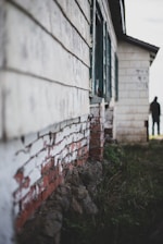 A team of real estate investors inspecting a worn-down house exterior on a sunny day.