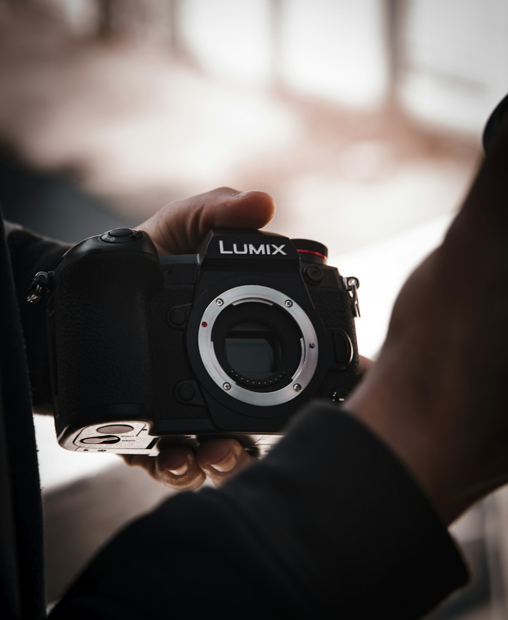 person holding black nikon dslr camera