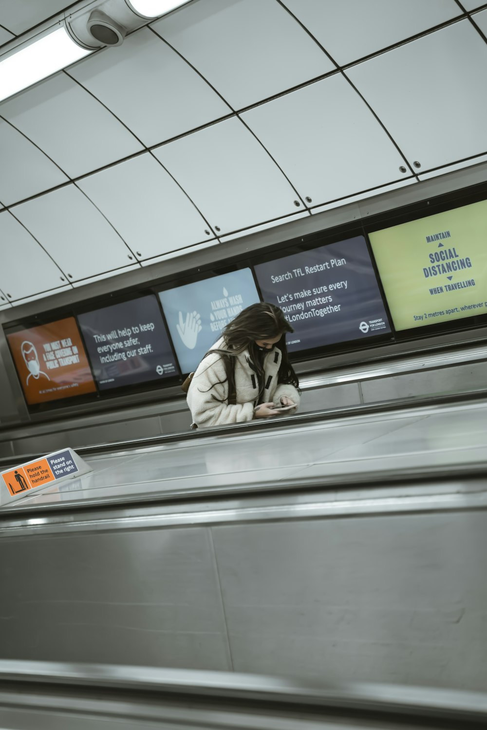 a woman sitting on an escalator in a subway station