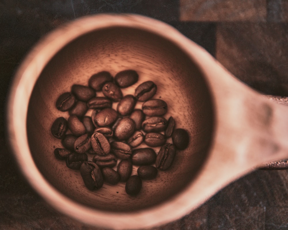 brown coffee beans in brown ceramic mug