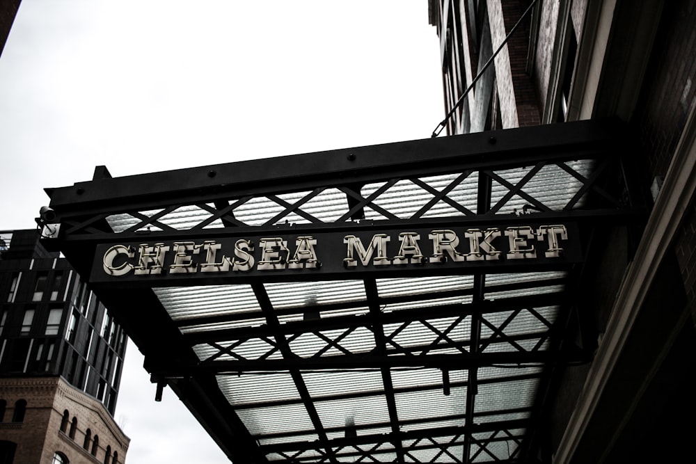 a sign for a cheese market hanging from a building