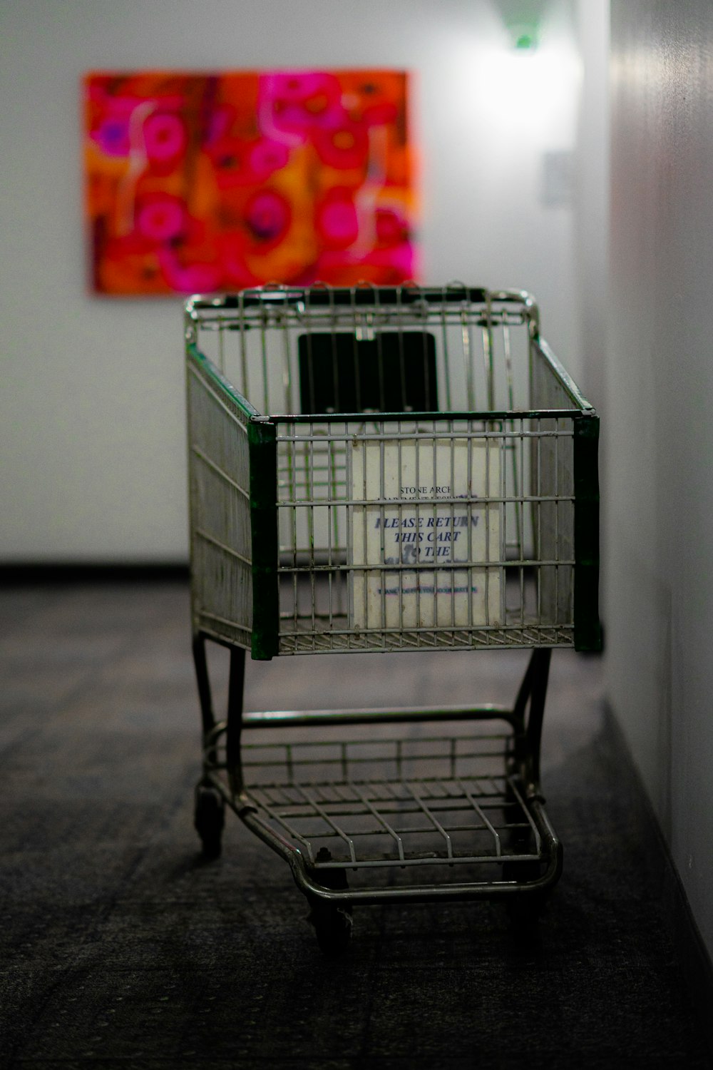 gray shopping cart near white wall