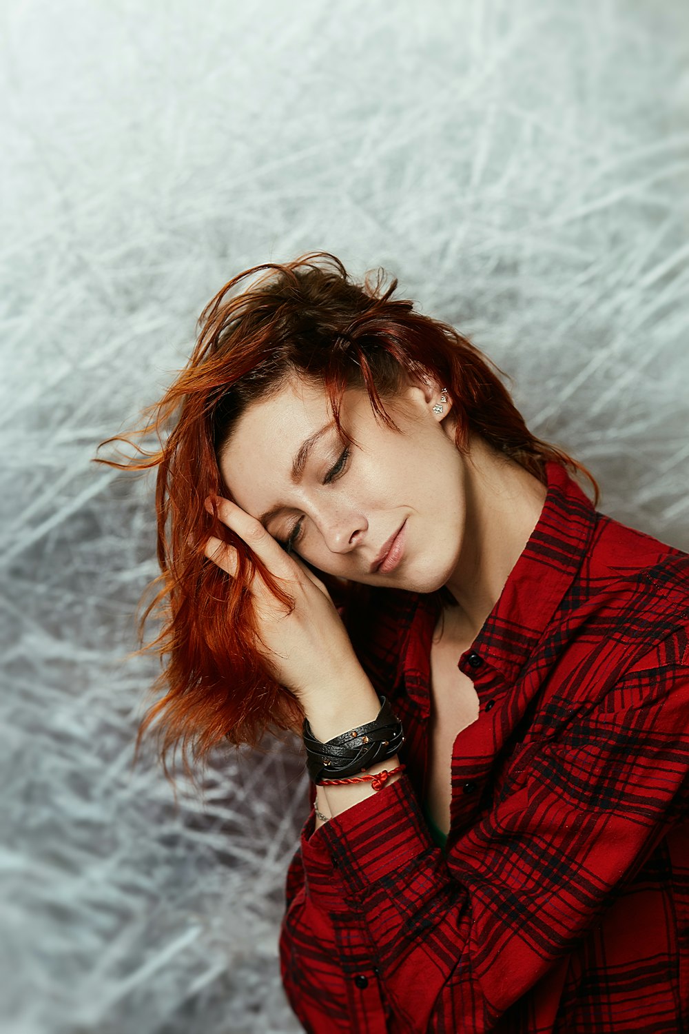 a woman with red hair is laying down