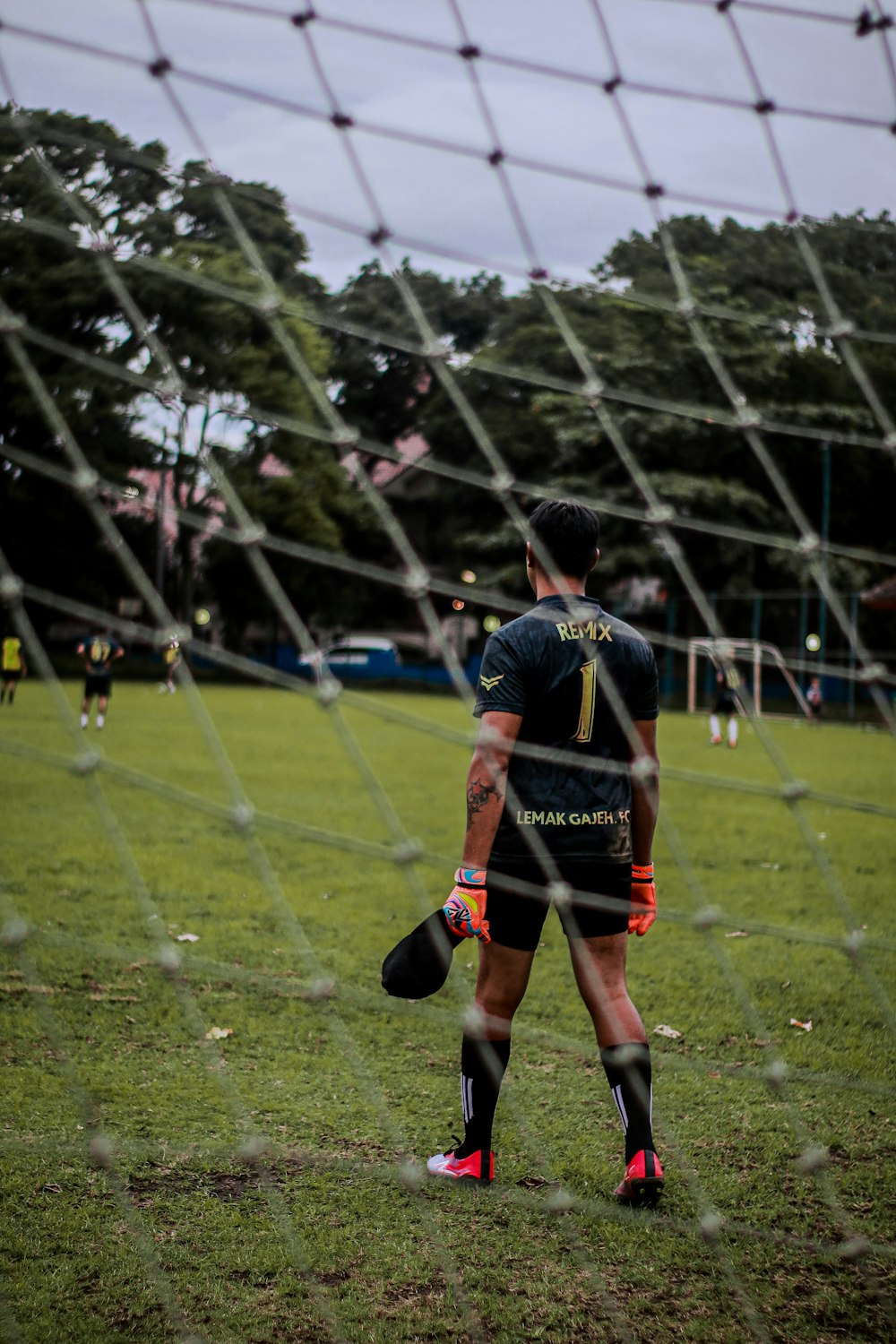 man in black and red jersey shirt playing soccer