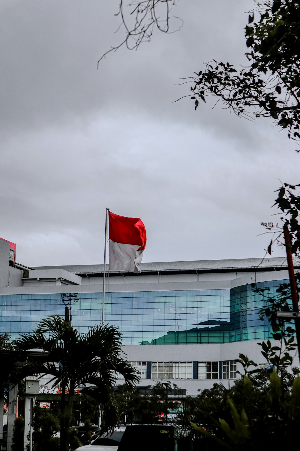 um grande edifício com uma bandeira vermelha e branca no topo dele