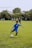 A young boy dribbling a soccer ball on a training field during practice.