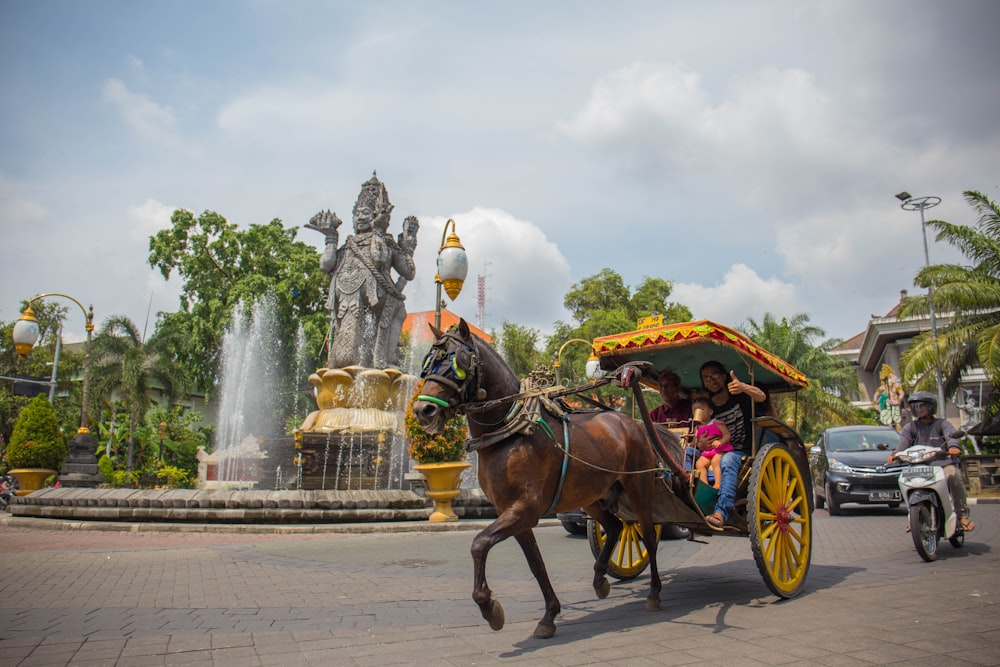 brown horse with carriage on road during daytime