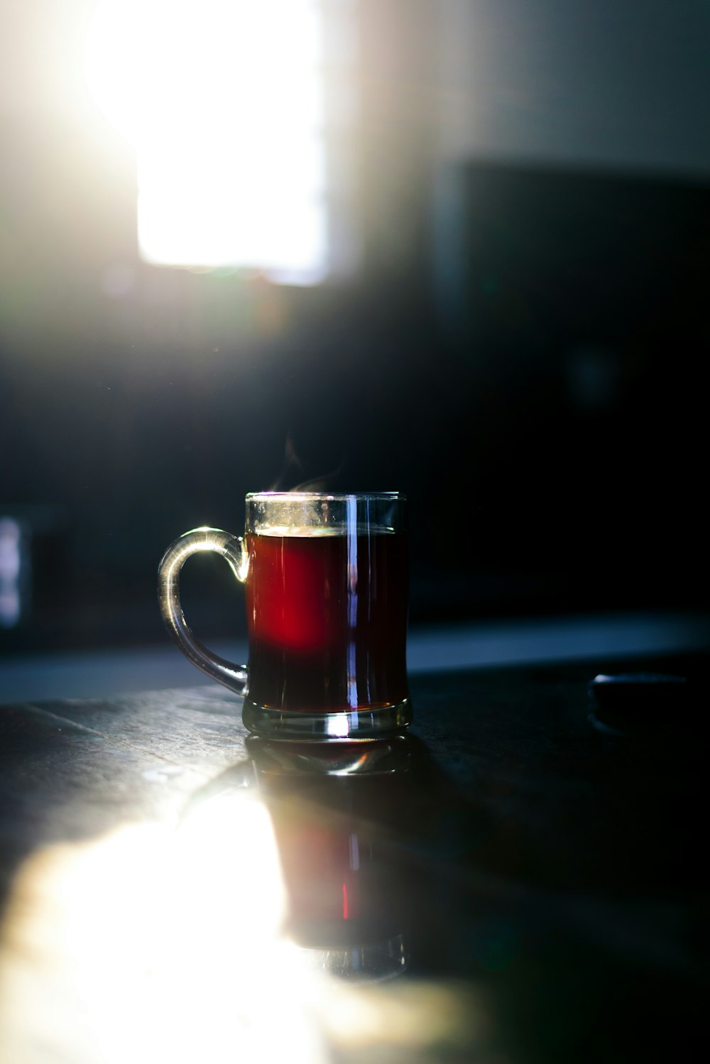 clear glass mug with brown liquid inside