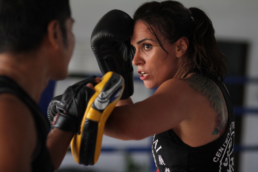 femme en débardeur noir portant des gants de boxe noirs