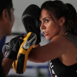 woman in black tank top wearing black boxing gloves